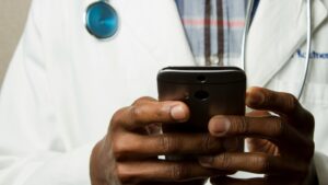 a black male doctor holding a phone